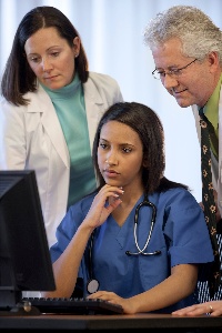 Picture of three people looking at a computer